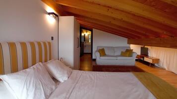Ein Schlafzimmer mit einem Bett, einem Sofa und einem Schreibtisch.