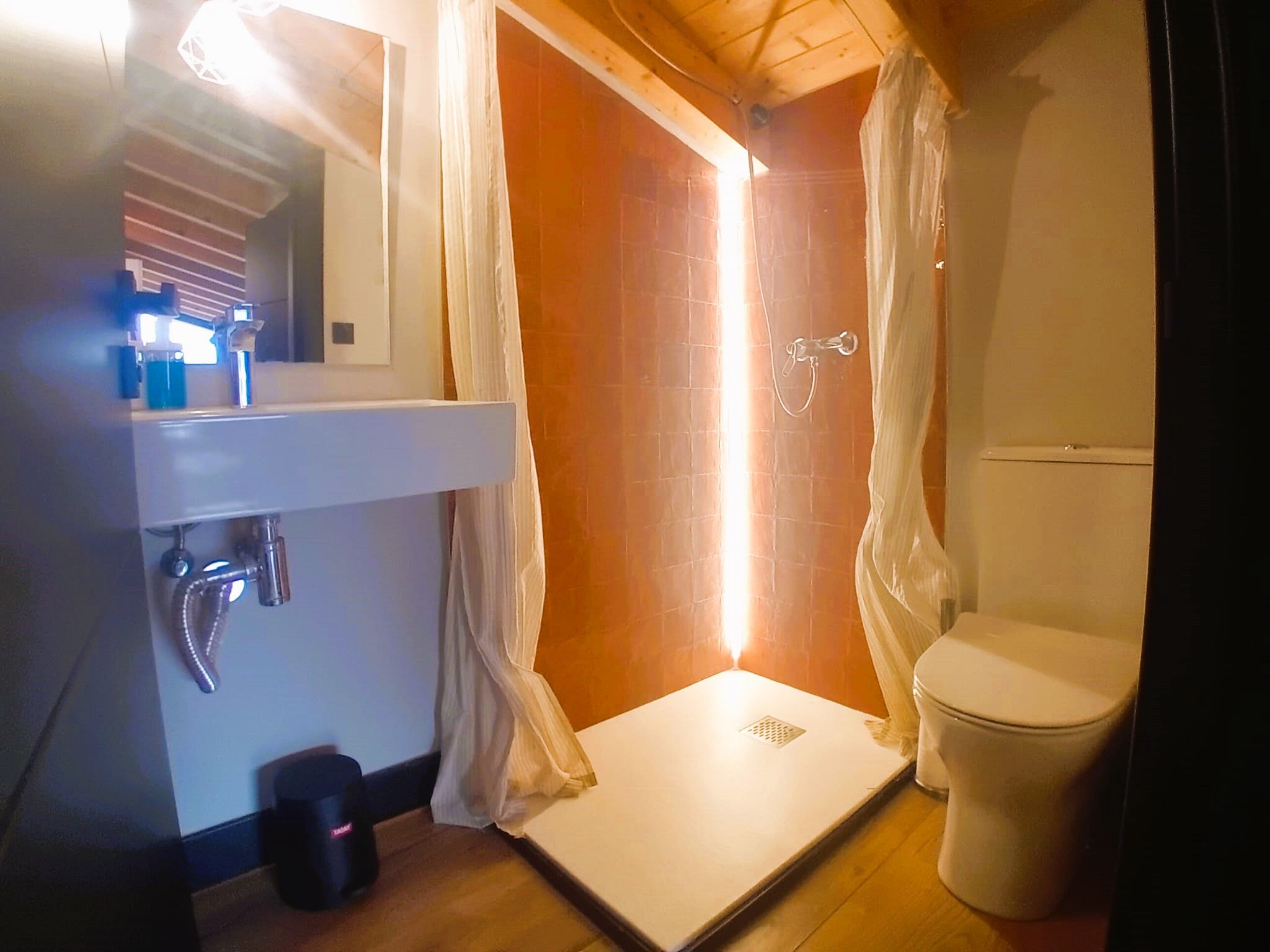 A small bathroom with a shower, toilet, and sink.
