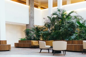 A spacious lobby with high ceilings, a central column, and a variety of seating arrangements. - Sphera Eilat (Eilat)