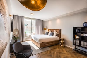 A modern hotel room with a large bed, a desk, a chair, and a bookshelf. - Sphera Eilat (Eilat)