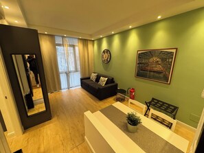 Ein modernes Wohnzimmer mit einer Couch, einem Couchtisch, einem Gemälde und einem Feuerlöscher.