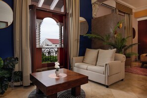 Ein Wohnzimmer mit einer Couch, einem Couchtisch und Blick auf ein Gebäude durch ein Fenster.
