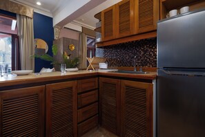 A modern kitchen with wooden cabinets, a stainless steel refrigerator, and a tiled backsplash. - Loft moderno para 2 personas | Plaza Bolívar, Casco Viejo. (Casco Viejo)
