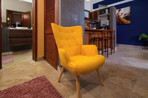A modern kitchen with wooden cabinets, a microwave, and a dining area with a table and chairs. - Loft moderno para 2 personas | Plaza Bolívar, Casco Viejo. (Casco Viejo)