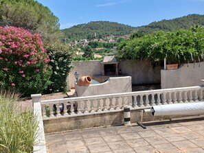 A terrace with a view of a village, a stone wall, and a water feature. - Les Ecologies, friendly but private with space to enjoy the views (Cessenon-sur-Orb)
