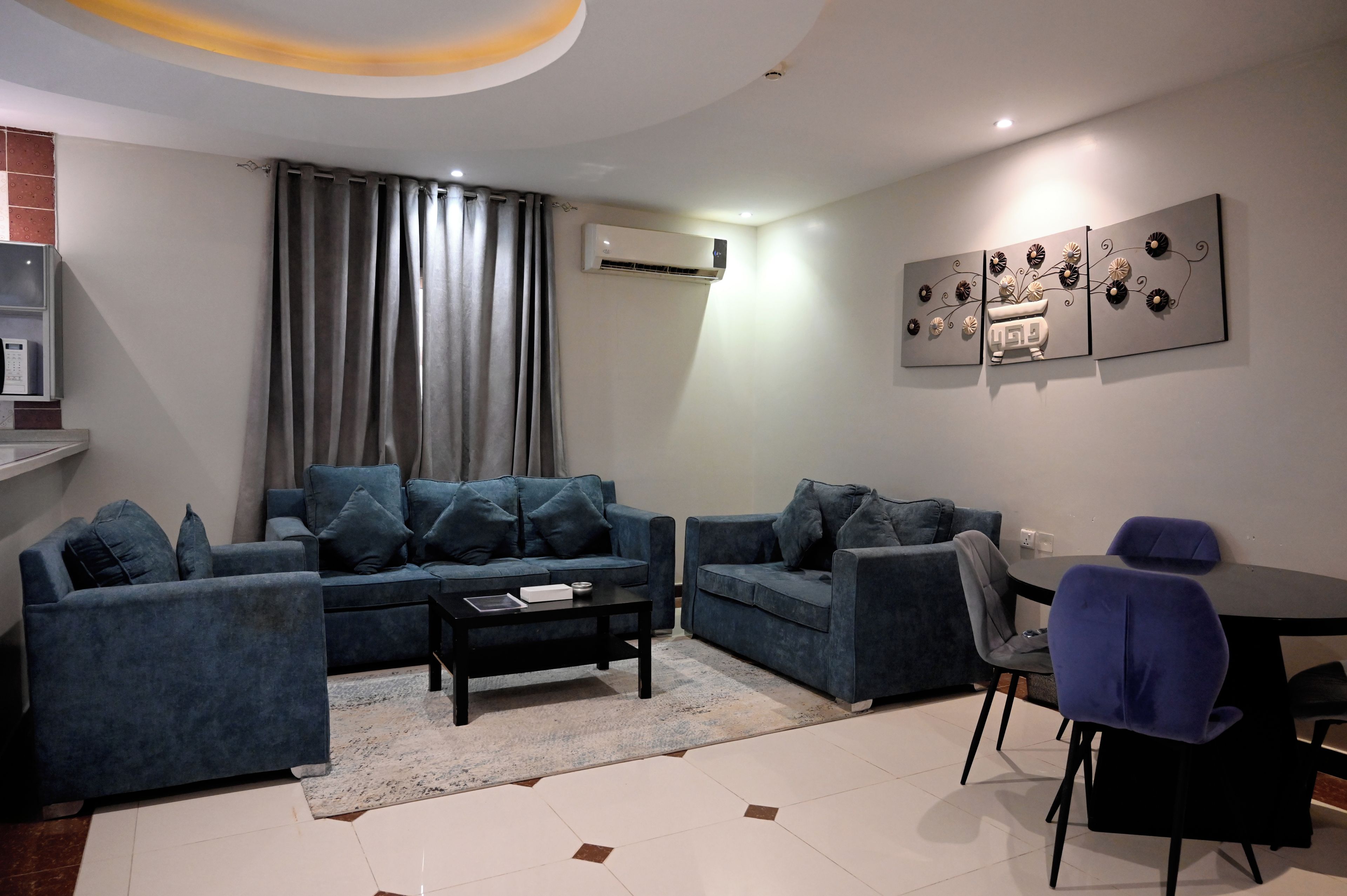 A modern living room with a sectional sofa, a coffee table, and a dining area with a chair.