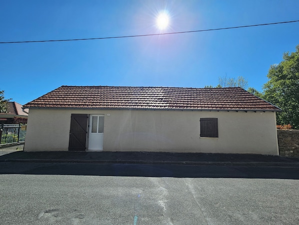 Un bâtiment d’un seul étage, doté d’un toit recouvert de tuiles, d’une porte et d’une petite fenêtre.