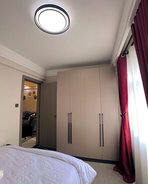 Ein Schlafzimmer mit einem Bett, einem Kleiderschrank und einer Deckenleuchte.