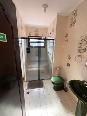 A bathroom with a glass shower enclosure, a toilet, and a sink. - Alessandra Ribeiro Squaiella (Caraguatatuba)