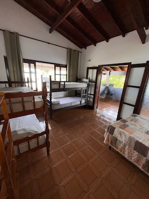 A room with bunk beds, a wooden table, and a chair. - Alessandra Ribeiro Squaiella (Caraguatatuba)