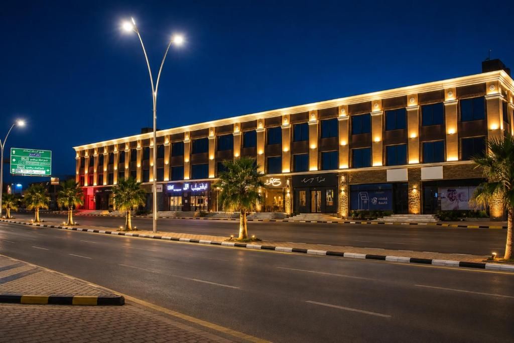 A multi-story hotel with a modern facade, illuminated windows, and a street view with palm trees and a road.