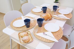 A table set with plates, mugs, and a pastry tray, suggesting a breakfast or snack setting. - New Listing (Napoli)