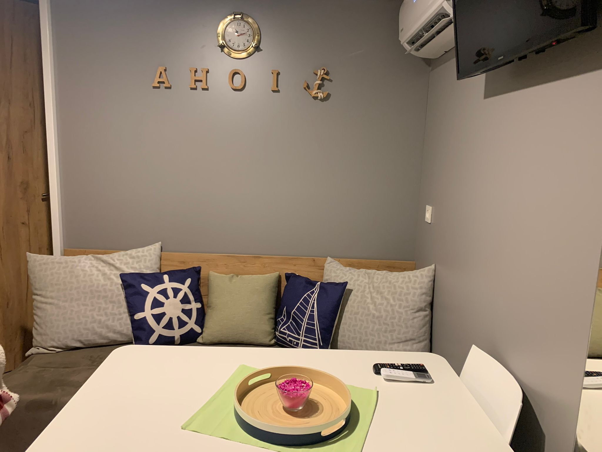 Una habitación con una cama, un reloj de pared y un aire acondicionado instalado.