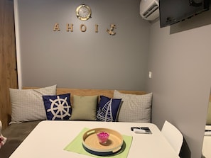 A room with a bed, a wall clock, and a mounted air conditioner. - Ahoi House 7 – Seaside mobile home in Drage, sleeps 6 (Drage)