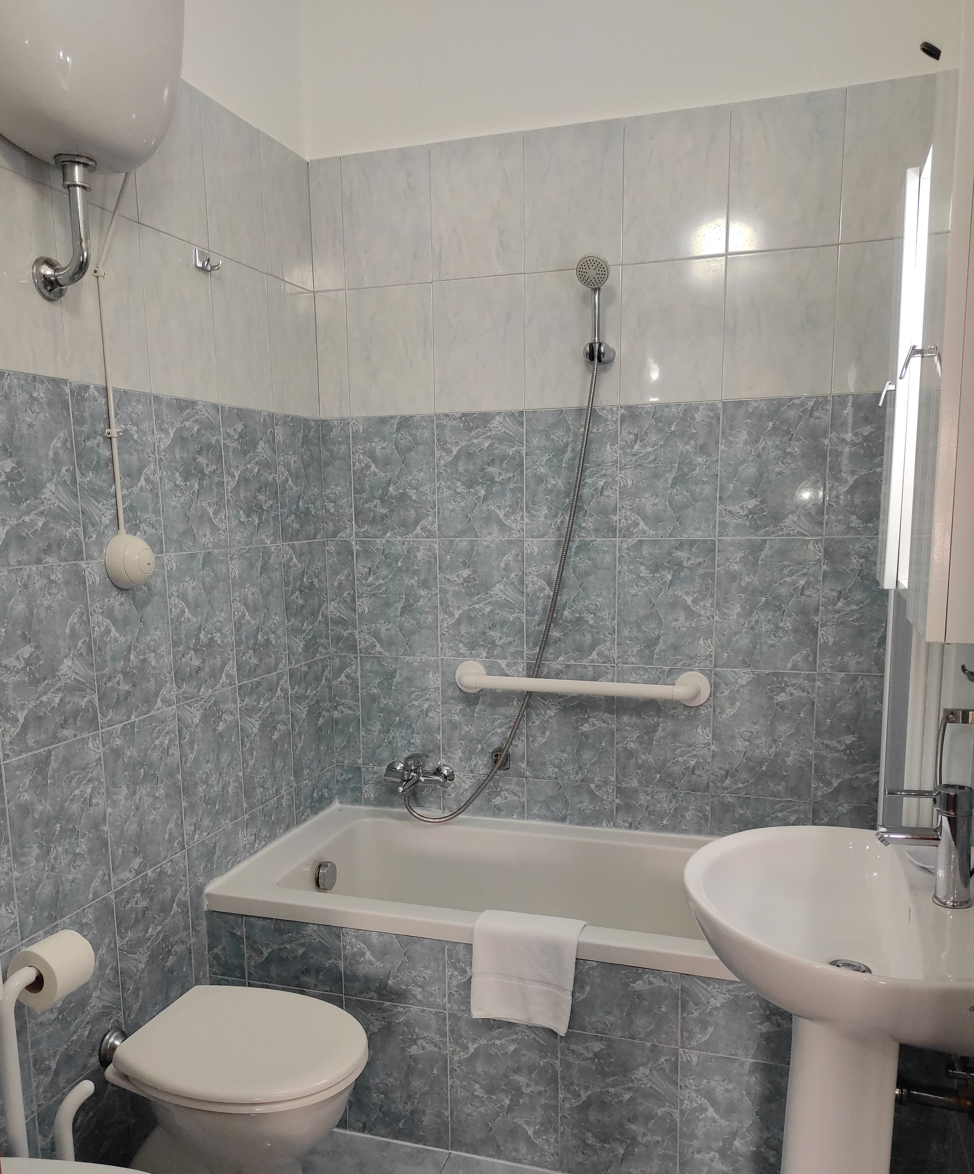 A bathroom with a bathtub, a toilet, and a sink.
