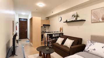 A modern living room with a sofa, a coffee table, and a TV stand.