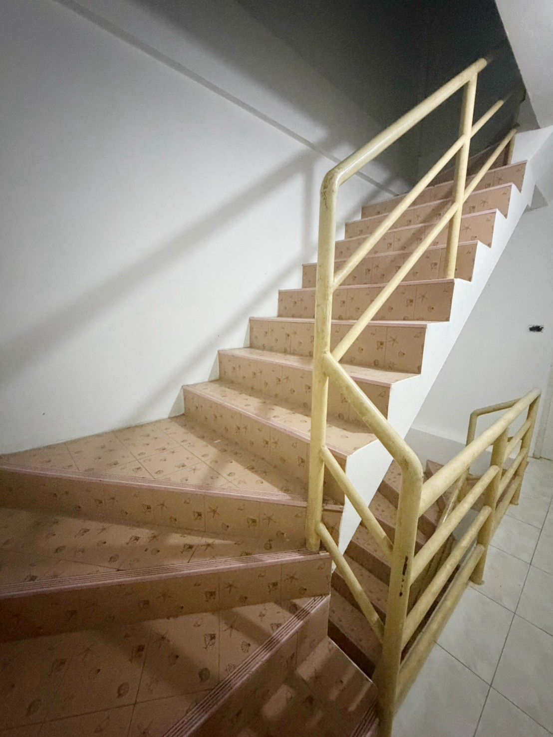 A staircase with a handrail and patterned steps.
