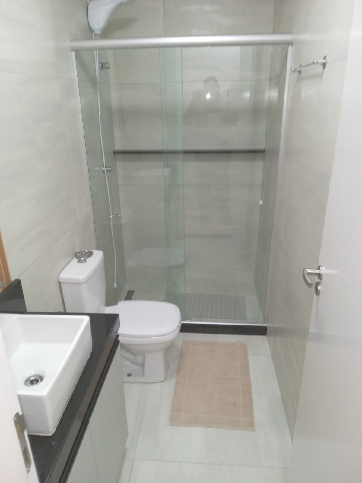 Ein Badezimmer mit einer Duschkabine, einer Toilette und einem Waschbecken.