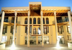 A multi-story building with a central atrium, large windows, and balconies. - Grand Ark Bukhara (Bukhara)