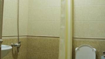 A bathroom with a shower, toilet, and sink.