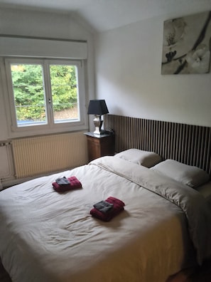 A bedroom with a bed, a window, a lamp, and a radiator. - New Listing (Ville-sur-Saulx)