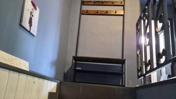 A staircase with a metal handrail and a wall-mounted rack.