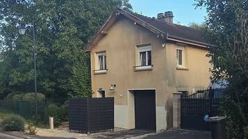 Una casa a due piani con un garage, un vialetto lastricato e un lampione.