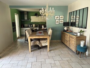 A dining area with a wooden table, chairs, and a chandelier. - New Listing (34920 le cres)