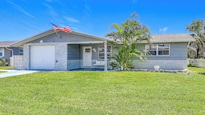 A single-story house with a garage, a front porch, and a small tree. - Waterfront 2-bedroom house with direct access to the Gulf in Hudson, Fl. (Hudson)