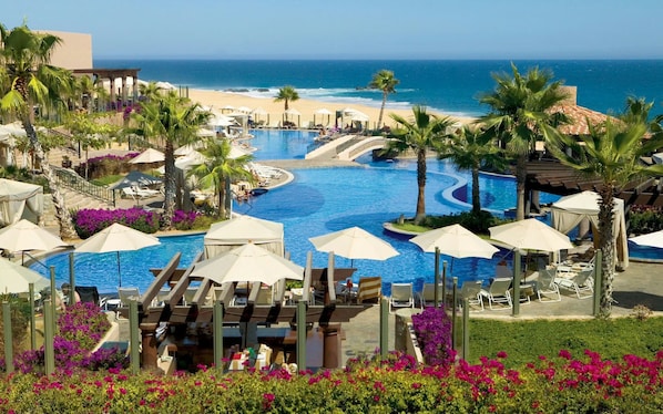 Ett semesterhotell med pool, strand och utsikt över havet.