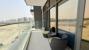 Un balcone con vista sulla città, con grattacieli e una strada trafficata.