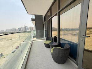 Un balcone con vista sulla città, con grattacieli e una strada trafficata.