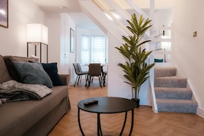 A modern living room with a sofa, a coffee table, and a staircase. - Perfect Booking 2-bed Near Folkestone Harbour (Folkestone)