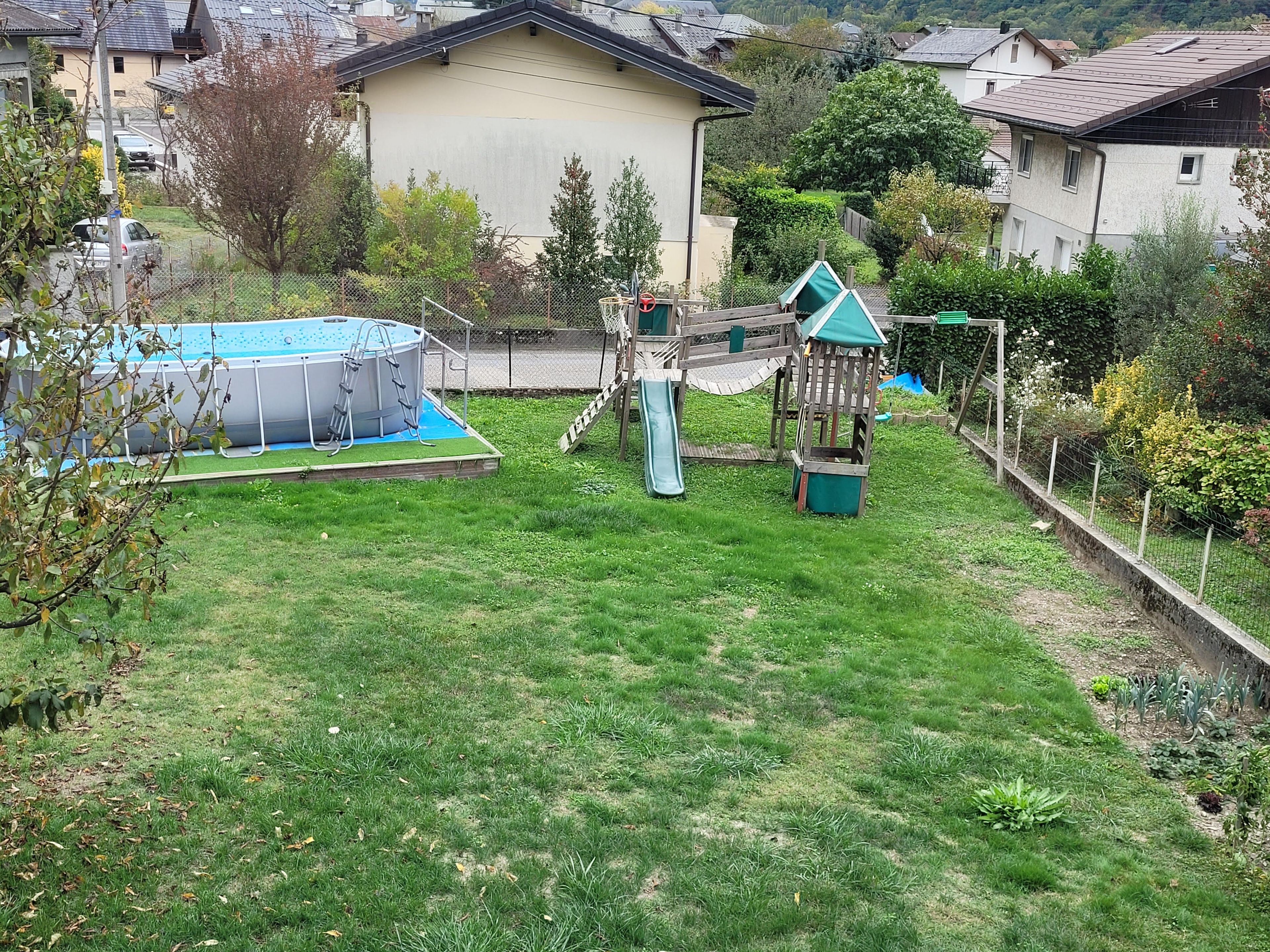 Un quartier résidentiel doté d’une piscine, d’un toboggan et d’un jardin clôturé.