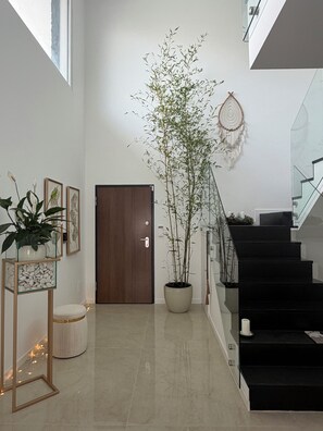 A modern interior with a staircase, a potted plant, and framed artwork on the wall. - Luxury New Lisbon/Beach Villa-3 bd, 4 bth, Jacuzzi, Fireplaces, Heated Salt Pool (Setúbal)