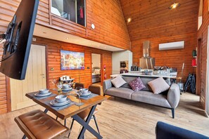 Un acogedor interior de cabaña con comedor, sofá y kitchenette.