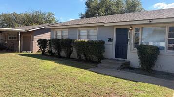 A single-story house with a front door, a garage, and a small front yard.