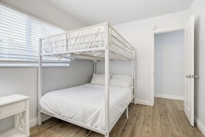 A bunk bed room with a window, a bedside table, and a door. - Short Walk To Sand Prefect For Families, Lrg Patio (Newport Beach)