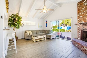 A spacious living room with a wooden floor, a grey sectional sofa, a coffee table, and a ceiling fan. - Short Walk To Sand Prefect For Families, Lrg Patio (Newport Beach)