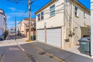 A residential street with houses, a garage door, and a trash bin. - Short Walk To Sand Prefect For Families, Lrg Patio (Newport Beach)