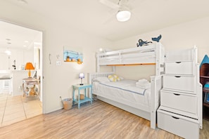 A compact room with a bunk bed, a small table with a lamp, and a shelf with decorative items. - Toes On The Sand, Perfect 4 Families, Amazing View (Ventura)