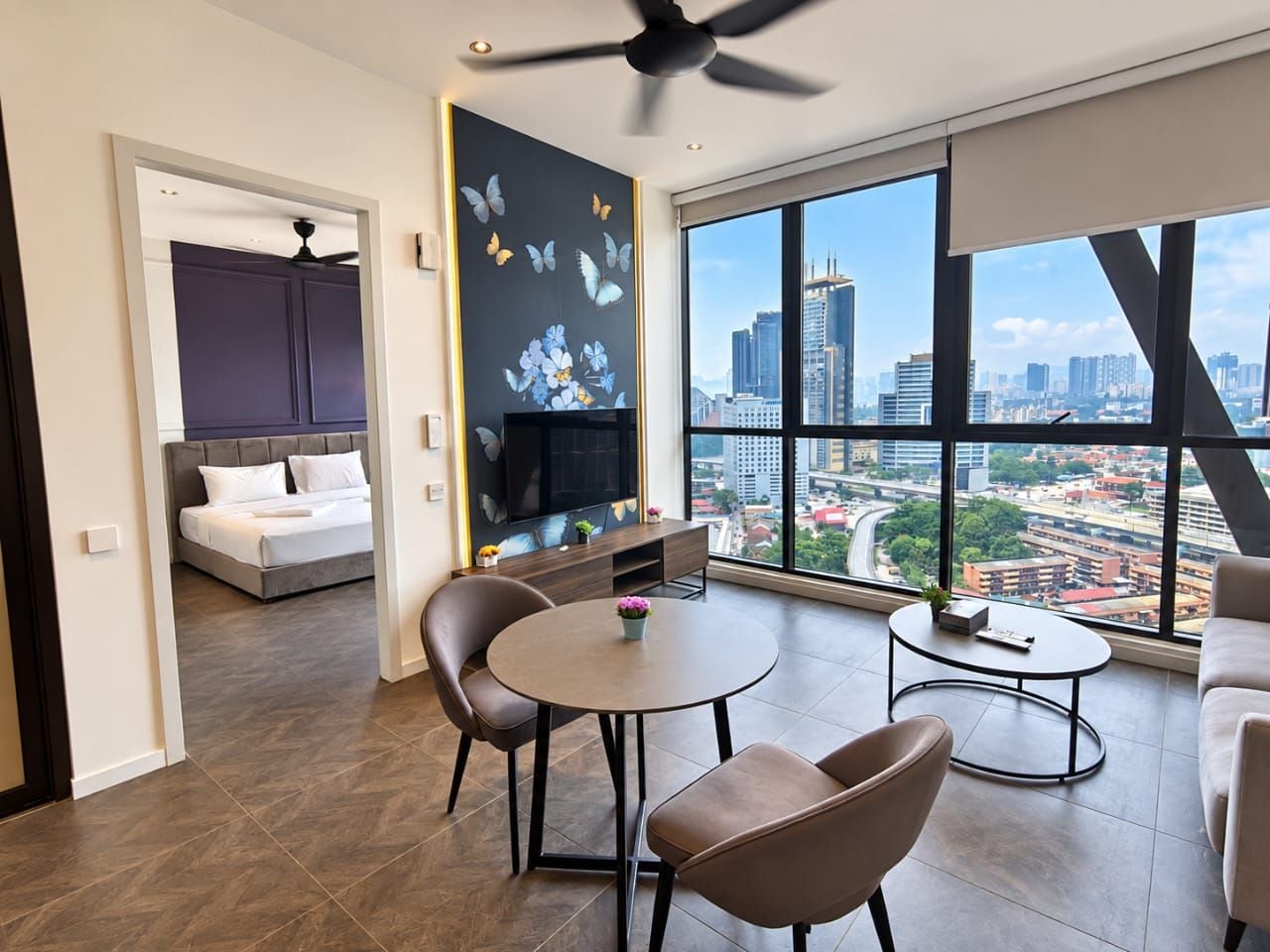 Una sala de estar moderna con vista a la ciudad, un comedor y un dormitorio con televisión.