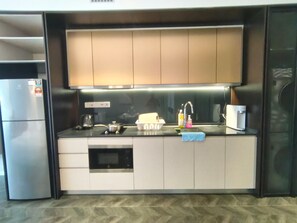 A modern kitchen with a built-in oven, microwave, and a coffee machine. - Scarletz KLCC By Solvane Hospitality  (Kuala Lumpur)