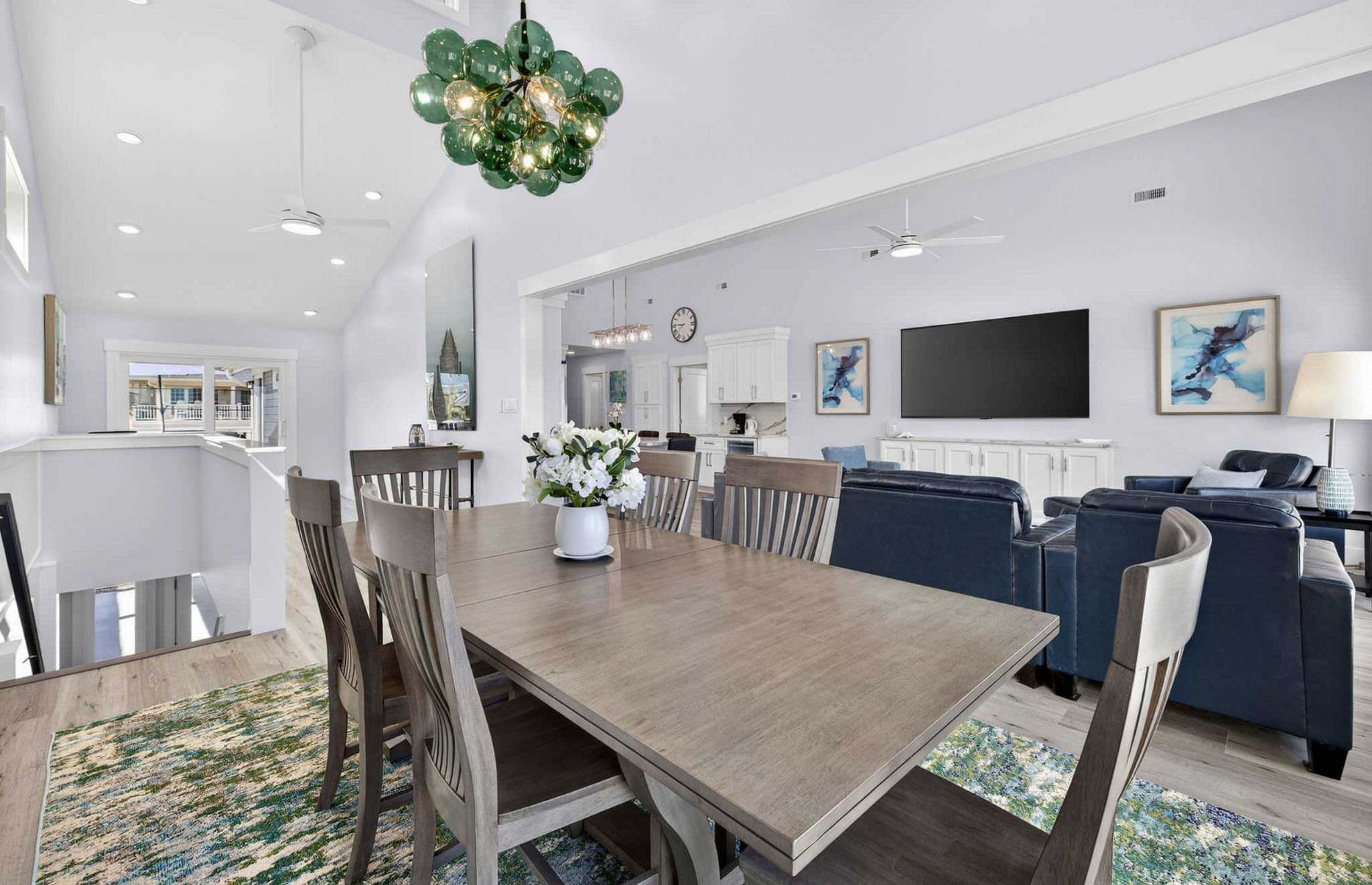 A spacious living area with a dining table, sofas, and a TV.