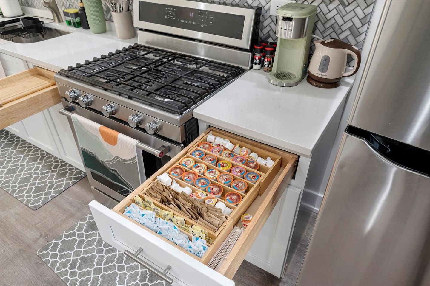 Une cuisine équipée d’une cuisinière, d’un four et d’un tiroir rempli de provisions.