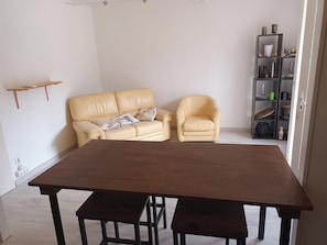 Una sala de estar con un sofá, una silla y una mesa de comedor.