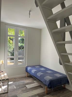 A room with a bed, a window, a lamp, and a staircase. - New Listing (Saint-Brevin-les-Pins)