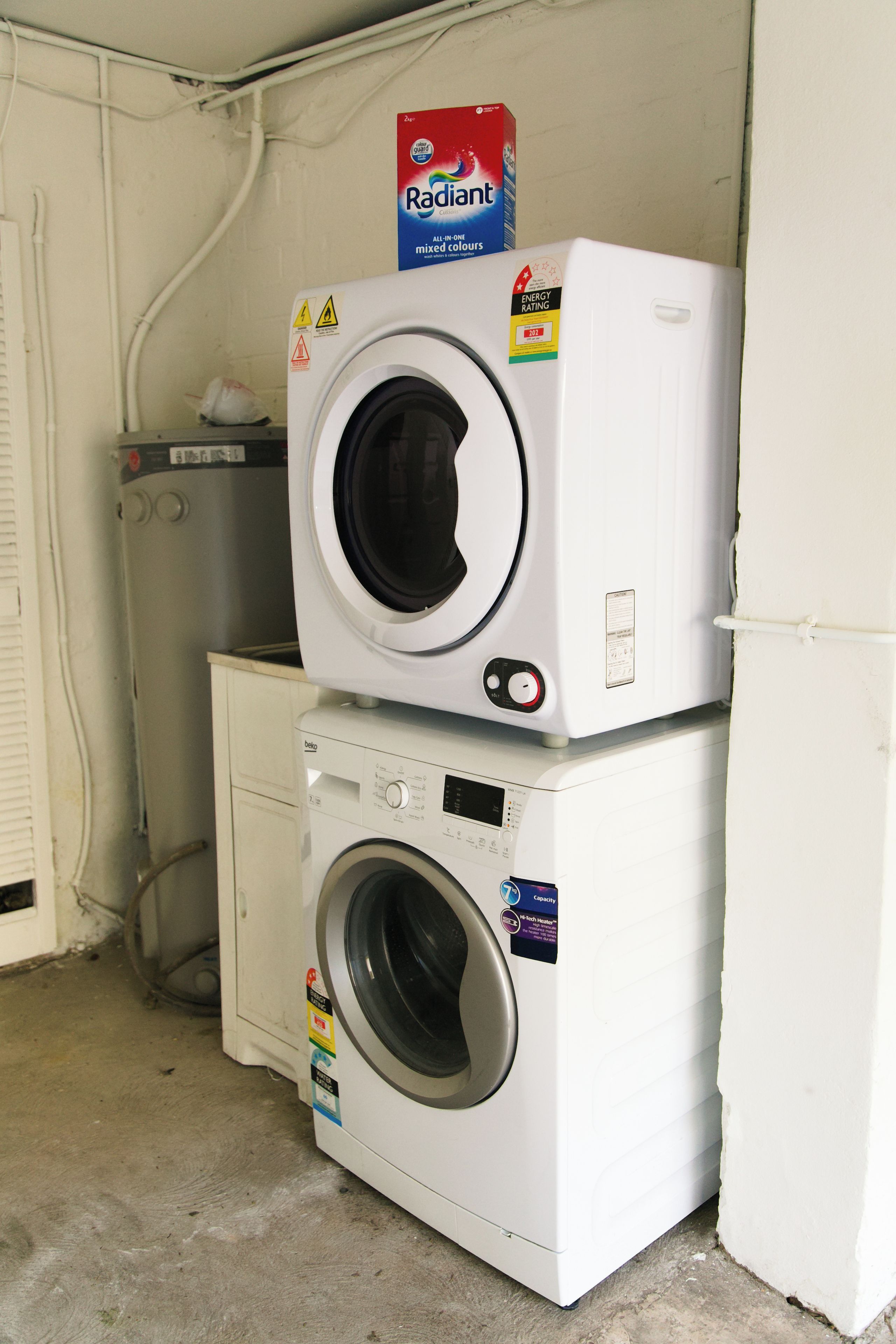 Two stacked washing machines in a utility room.