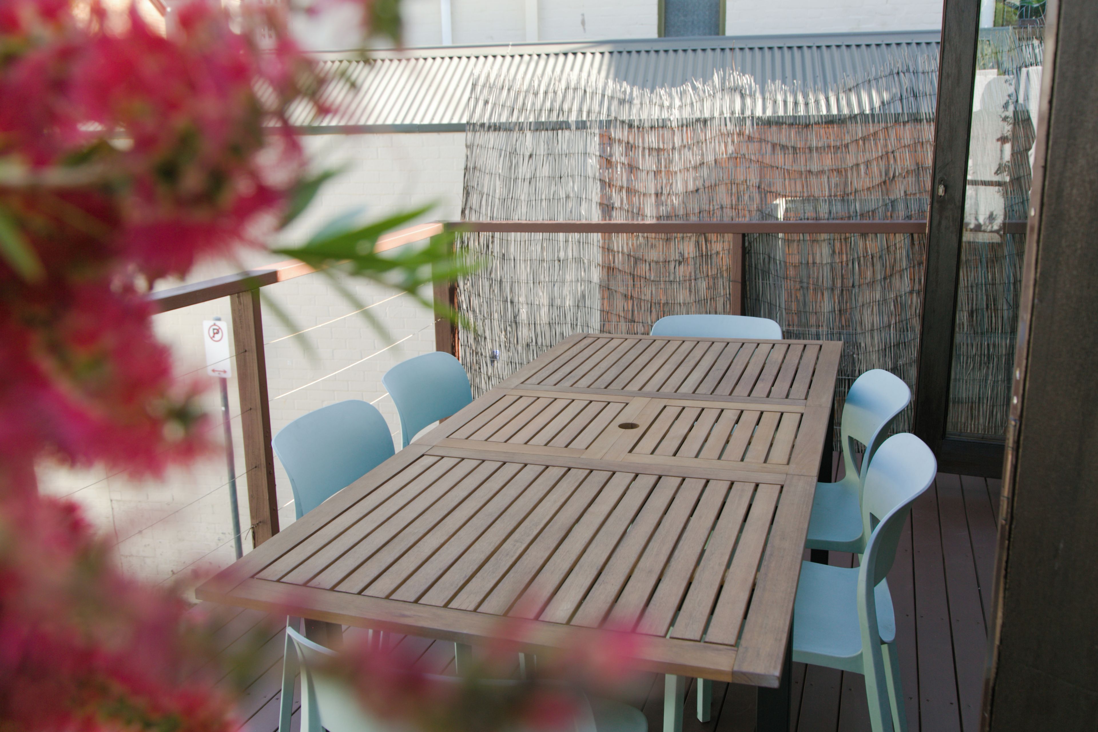 A wooden table with chairs on a balcony.