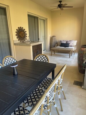 Un comedor con una mesa, sillas, un ventilador de techo, un sofá y una chimenea.